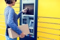 Woman using automated self service post terminal machine or lock Royalty Free Stock Photo