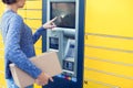 Woman using automated self service post terminal machine or lock Royalty Free Stock Photo