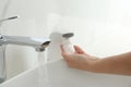 Woman using automatic soap dispenser in bathroom Royalty Free Stock Photo