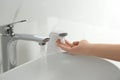 Woman using automatic soap dispenser in bathroom Royalty Free Stock Photo