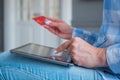 Woman using black tablet and red credit card for online shopping Royalty Free Stock Photo