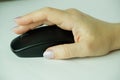 Woman using a black wireless computer mouse on white background. A woman's hand holds a computer mouse. Working with th Royalty Free Stock Photo