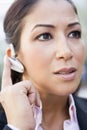 Woman using bluetooth earpiece Royalty Free Stock Photo