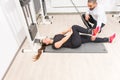 Woman using cable machine with personal trainer Royalty Free Stock Photo