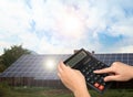 Woman using calculator against house with solar panels. Renewable energy and money saving Royalty Free Stock Photo