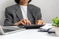 woman using calculator and laptop on desk about cost at home office.Business investment Financing Accounting Banking tax Concept Royalty Free Stock Photo