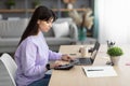 Woman using calculator working on laptop at home Royalty Free Stock Photo