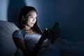 Woman using cellphone on bed Royalty Free Stock Photo