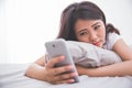 Woman using cellphone on the bed Royalty Free Stock Photo