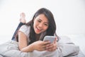 Woman using cellphone on the bed Royalty Free Stock Photo