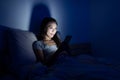 Woman using cellphone on bed at night Royalty Free Stock Photo