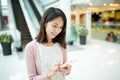 Woman using cellphone inside shopping mall Royalty Free Stock Photo