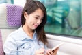 Woman using cellphone on train compartment Royalty Free Stock Photo