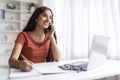 Woman Using Cellphone And Working On Laptop At Home Office Royalty Free Stock Photo