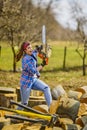 Woman using chainsaw to cut a log for firewood Royalty Free Stock Photo