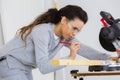 Woman using circular saw marking wood Royalty Free Stock Photo