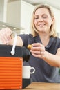 Woman Using Coffee Capsule Machine In Kitchen Royalty Free Stock Photo