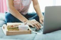 Woman using computer and having breakfast in bed for staying and working at home concept Royalty Free Stock Photo