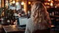 Woman Using a Computer Notebook Laptop in a Public Space Cyber Cafe Coffee Shop Searching Researching Googling on a Search Engine