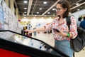 Woman using contactless kiosk