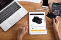 Woman using credit card for buy black running shoes on ecommerce website via tablet with laptop, smartphone and office stationery Royalty Free Stock Photo