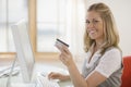 Woman using credit card and computer