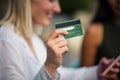 Woman using credit card and mobile phone. Focus is on credit card Royalty Free Stock Photo