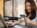 Woman using credit card to shop online. shoping personal belongings through various web application applications in notebook