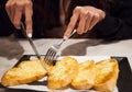 Woman using cutlery cut freshly Baked Tasty Homemade Garlic Bread servings. Food ingredient, bakery, pastry, snack, appetizer, Royalty Free Stock Photo