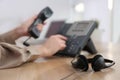 Woman using desktop telephone in office, focus on headset. Hotline service Royalty Free Stock Photo