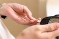 Woman using digital glucometer checking blood sugar level Royalty Free Stock Photo