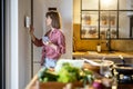 Woman using digital tablet, controlling smart home devices in the kitchen Royalty Free Stock Photo