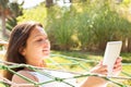 Woman using digital tablet in hammock at park Royalty Free Stock Photo