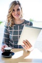 Woman using digital tablet while having cup of coffee Royalty Free Stock Photo