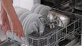 Woman using dish washing machine at kitchen. Royalty Free Stock Photo