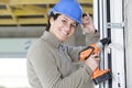 woman using drill on ladder