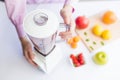 Woman using electric juicer to prepare fruit healthy meal in kitchen Royalty Free Stock Photo