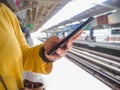 Woman using finger touch on the screen of mobile phone on BTS sky train background Royalty Free Stock Photo