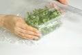 Woman using food film for food storage on a white table. Roll of transparent polyethylene food film for packing products Royalty Free Stock Photo