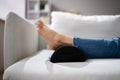 Woman Using Footrest To Reduce Back Strain