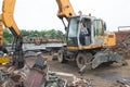 Woman using grabber in scrapyard Royalty Free Stock Photo