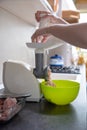 Woman using grinder for preparation of minced meat in kitchen Royalty Free Stock Photo