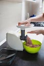 Woman using grinder for preparation of minced meat in kitchen Royalty Free Stock Photo