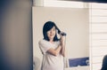 Woman using hair irons with straightening Royalty Free Stock Photo