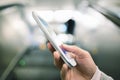 Woman using her cell phone in Subway on escalator Royalty Free Stock Photo