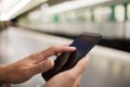 Woman using her cell phone on subway platform Royalty Free Stock Photo