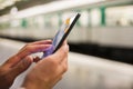 Woman using her cell phone on subway platform Royalty Free Stock Photo