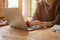 A woman using her laptop at a table in a beautiful, cosy coffee shop. typing on keyboard