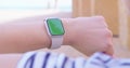 Woman using her smartwatch touchscreen with greenscreen.