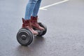 Close up of woman using hoverboard on asphalt road. Feet on electrical scooter outdoor Royalty Free Stock Photo